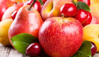 Assorted stone fruits, such as apples, cherries, pears, nectarines, peaches, plums and combined on a wooden table