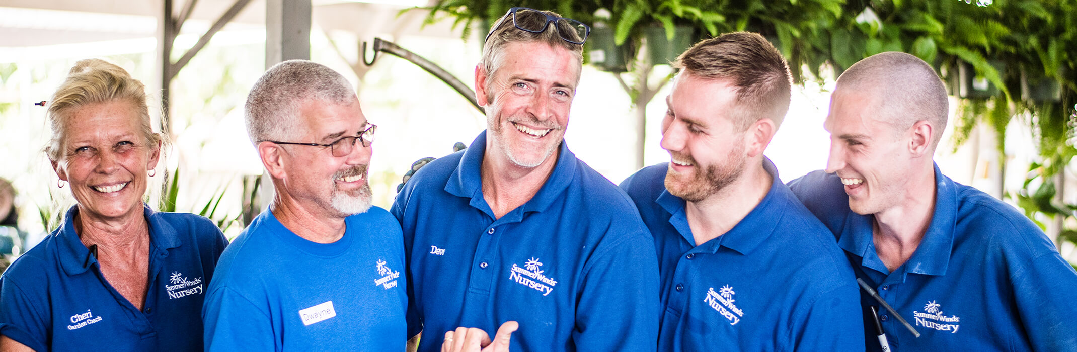 1 female and 4 male associates at SummerWinds Nursery in their blue shirts