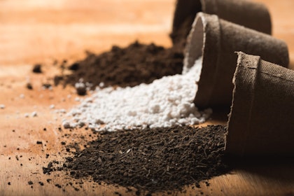 3 pulp pots with three different soil amendments spilling out of them onto the table