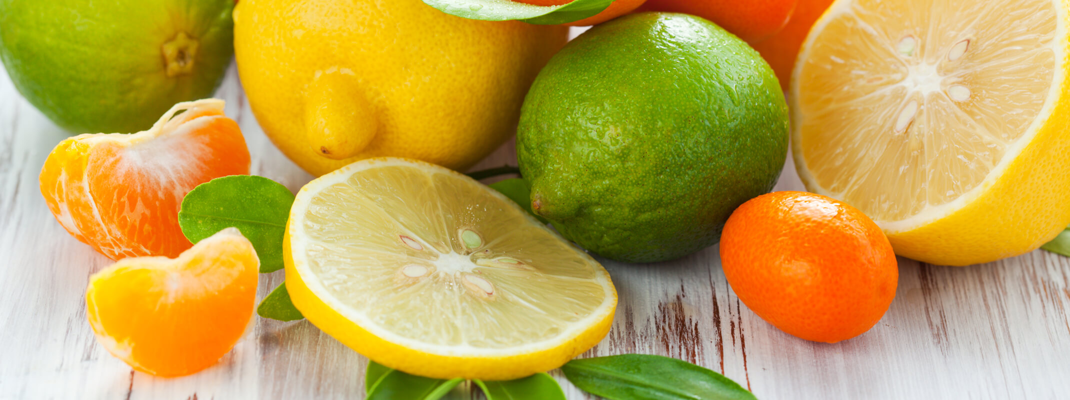 Assorted citrus fruits slices, halves and wholes sitting on table.