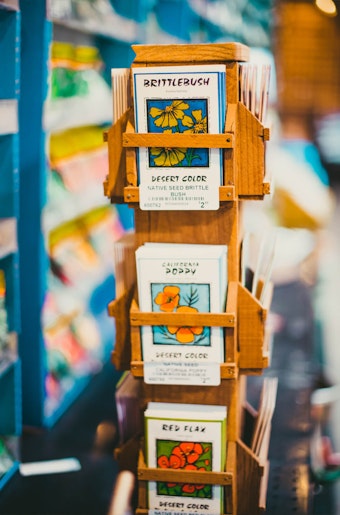 A closeup of a wooden display holding a vareity of native flower seeds from The Native Seed Company