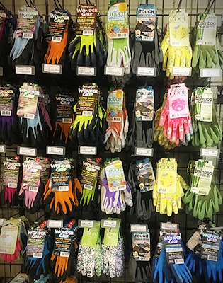 assorted gardening gloves hanging on pegs on wall for sale