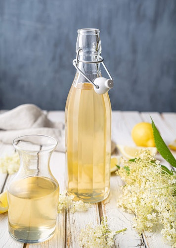 Simple syrup in bottle on table with ingredients lying around