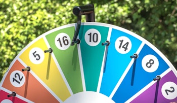 colorful prize wheel outdoors with lush green foliage in the background