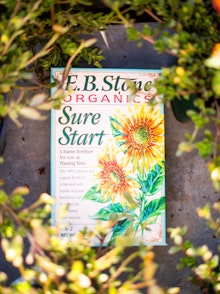 E.B. Stone Organics Sure Start Fertilizer surrouned by plants.