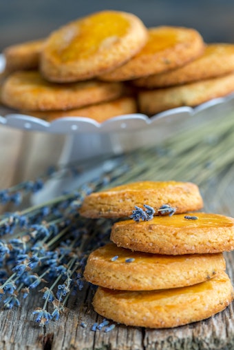 Lavender mint cookies with lavender sprigs on a wooden table and in a bowl.