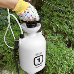 woman holding and using centurion 1 gallon garden sprayer