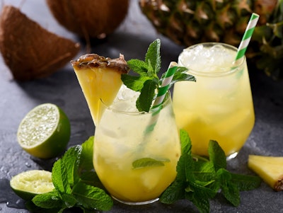 tropical limeade sparkler mocktail with citrus garnished with mind and pineapple