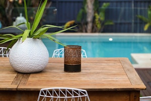 A table and chairs for poolside outdoor dining.