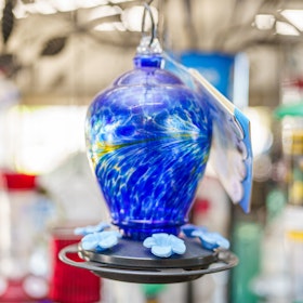 Blue and yellow blown glass hummingbird feeder.