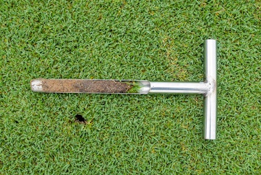 A soil probe on grass.
