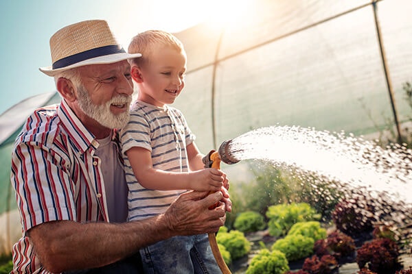 grandfather teaching grandson gardening watering summerwinds california