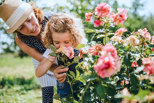 mother and daughter smelling roses summerwinds california