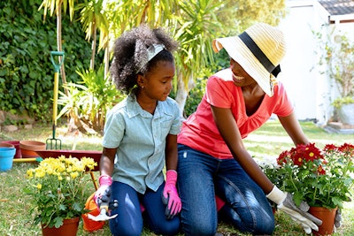 mother and daughter planting flowers in garden summerwinds california