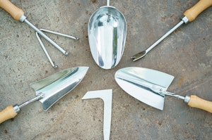 A close up of six different SummerWinds hand tools in a circle on the concrete.
