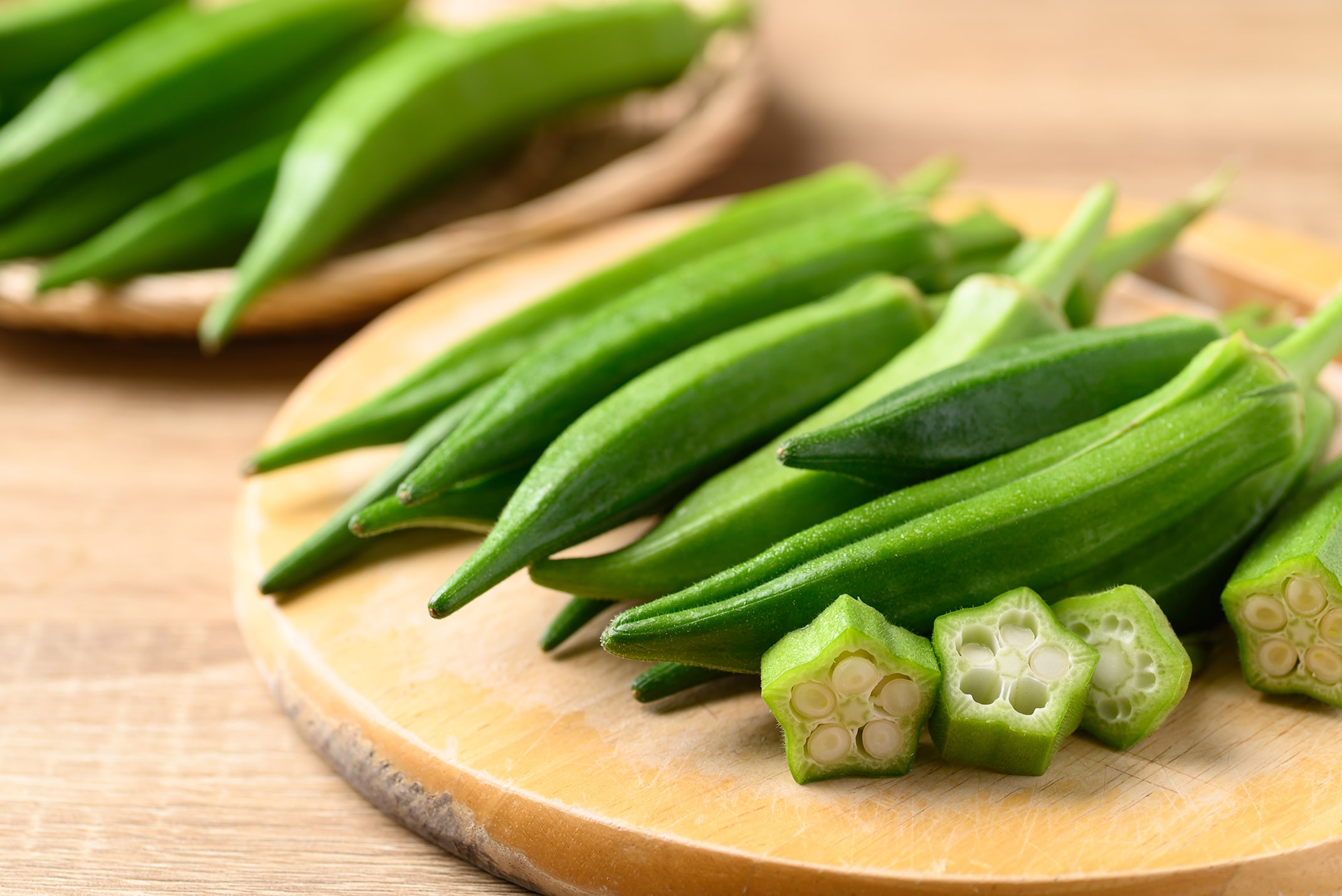 Okra cut and whole on cuttting board.