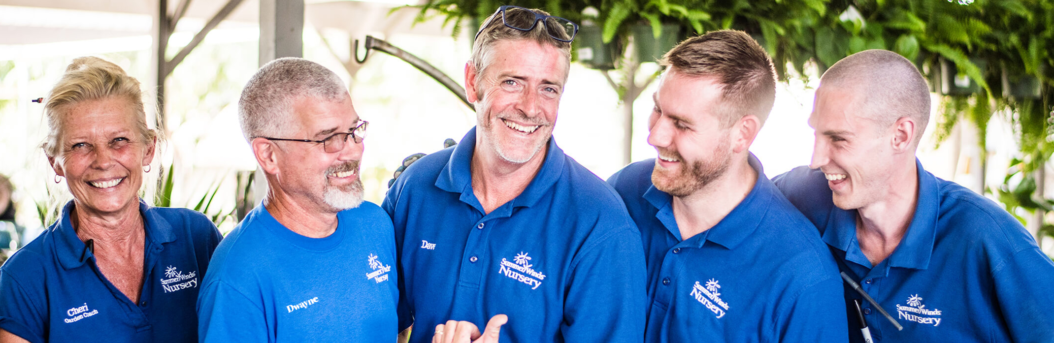 1 female and 4 male associates at SummerWinds Nursery in their blue shirts