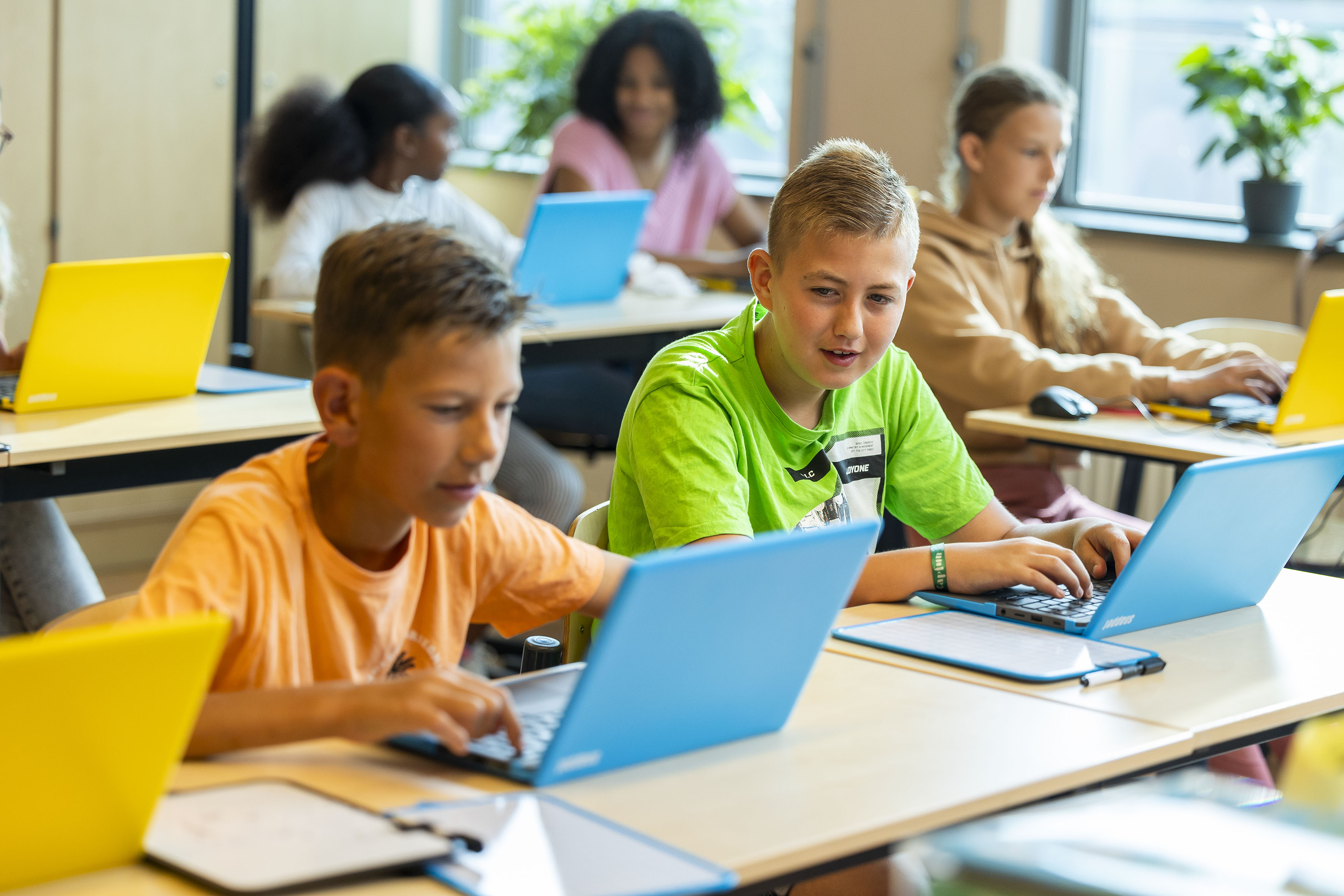 Leerlingen werken in lokaal op laptops