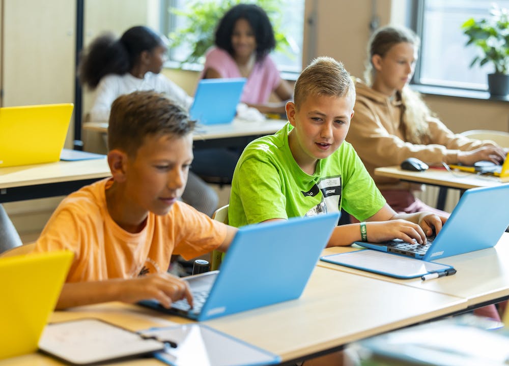 Leerlingen werken in lokaal op laptops