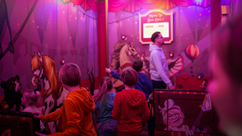 Trois enfants et un adulte s'amusant dans l'activité Funfair Games de Koezio