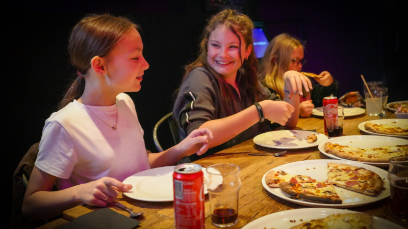 Trois enfants fêtant un anniversaire en mangeant des pizza