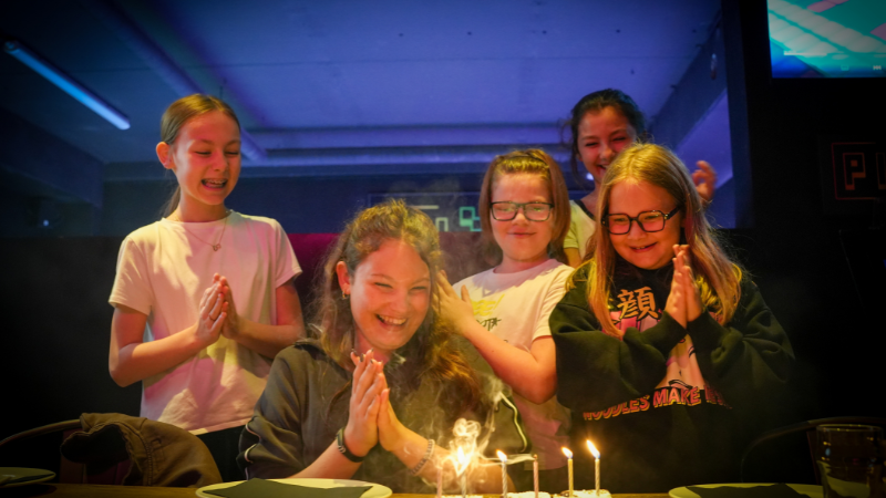 Cinq enfants fêtant un anniversaire avec un gâteau et des bougies