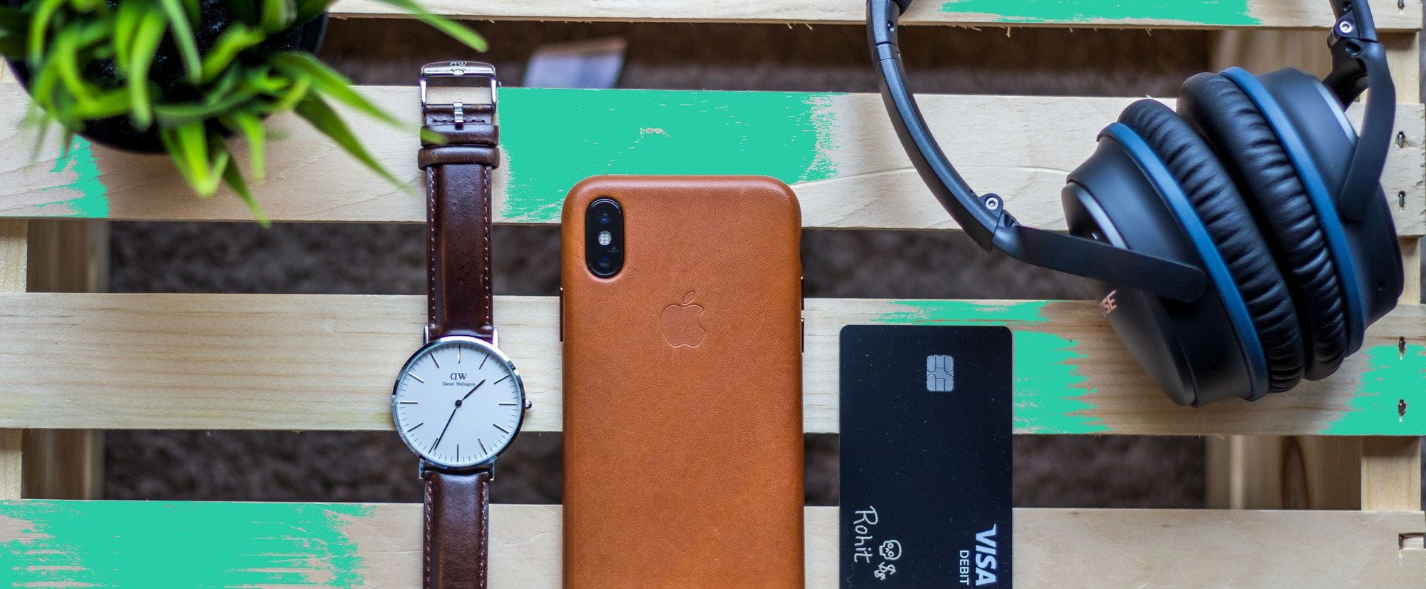 Image of a watch. phone, credit card, and headphones