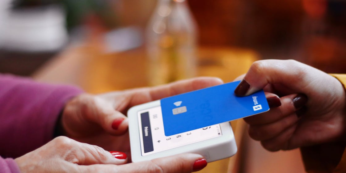 A woman tapping her credit card to pay