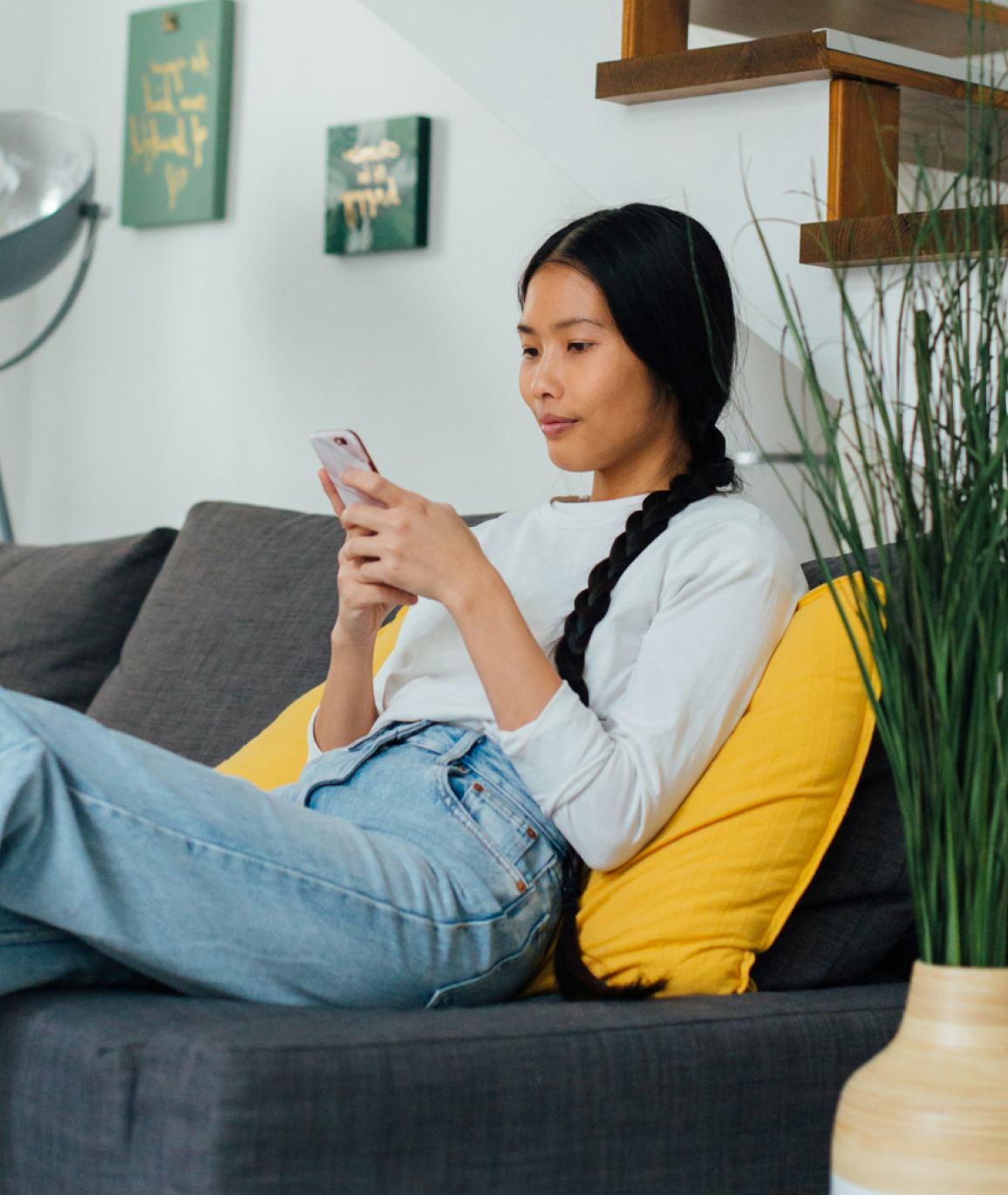 Woman sitting on a couch with her phone