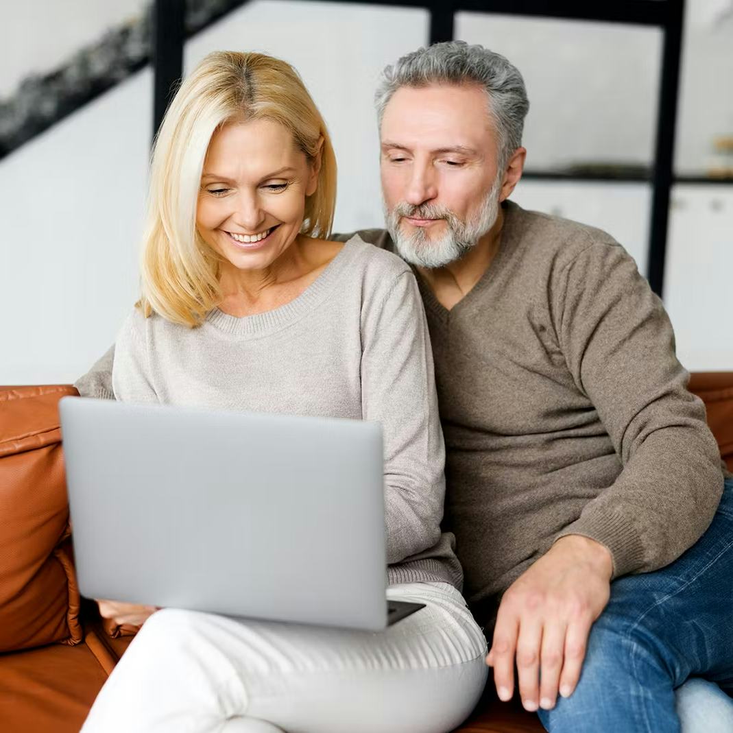 Older couple paying off their debts on a computer