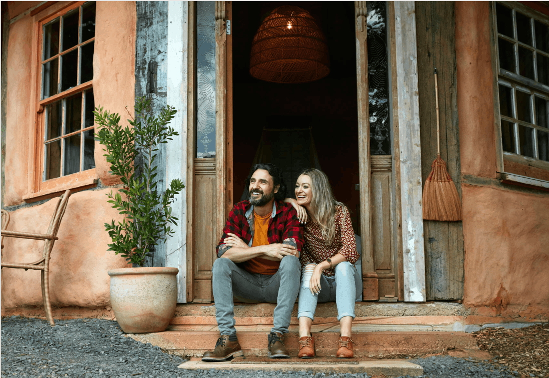 Man and woman sitting in the doorway of a home