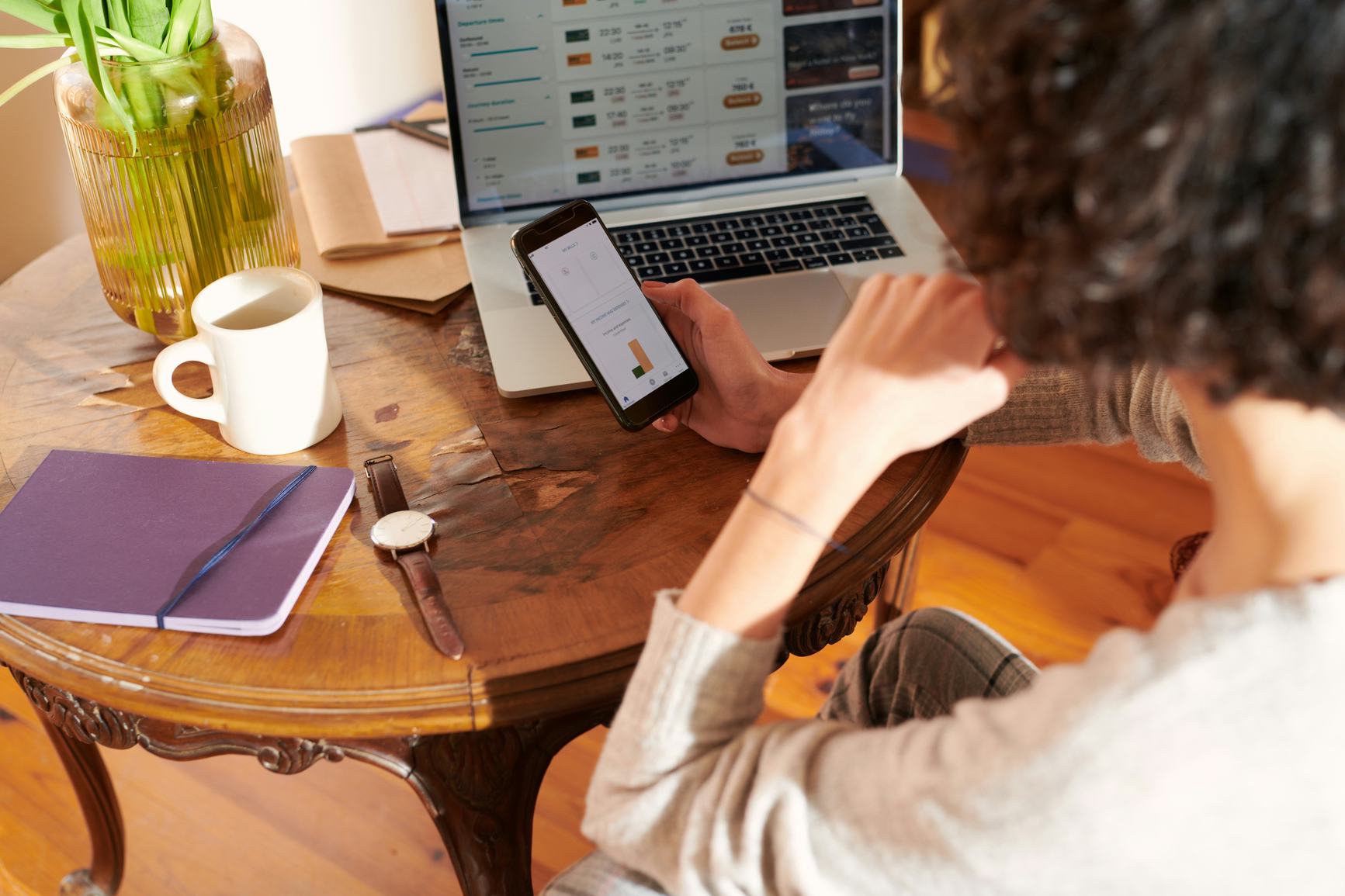 Woman looking at her laptop and phone