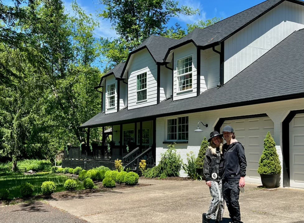 Couple standing in front of their new home