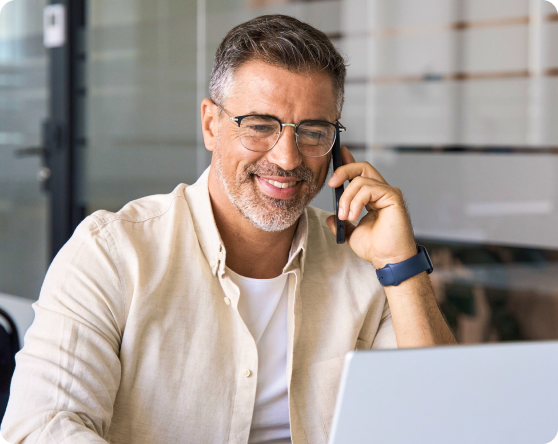 Man on the phone looking at his laptop
