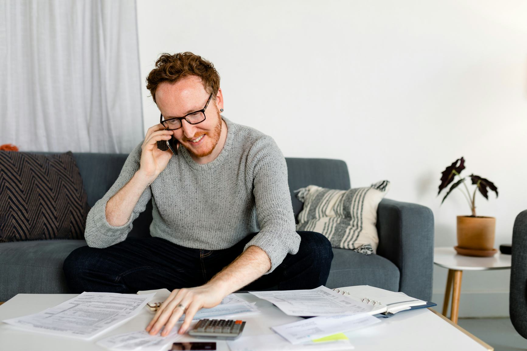 Man looking over his finances while on the phone