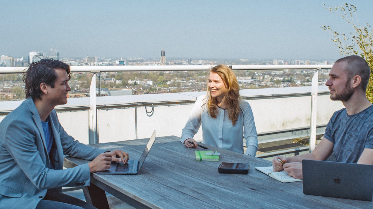 Collega's vergaderen op het dakterras met uitzicht over Utrecht
