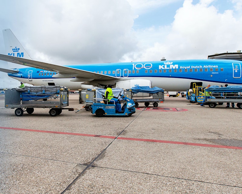 Een KLM vliegtuig staat naast de gate en wordt ingeladen