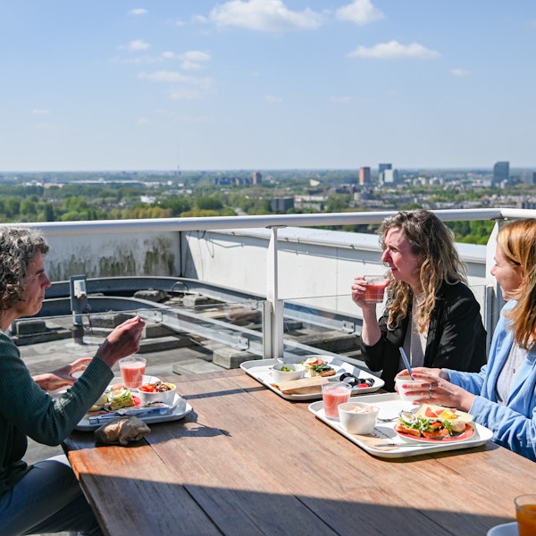 Collega's lunchen op het dakterras met uitzicht over Utrecht