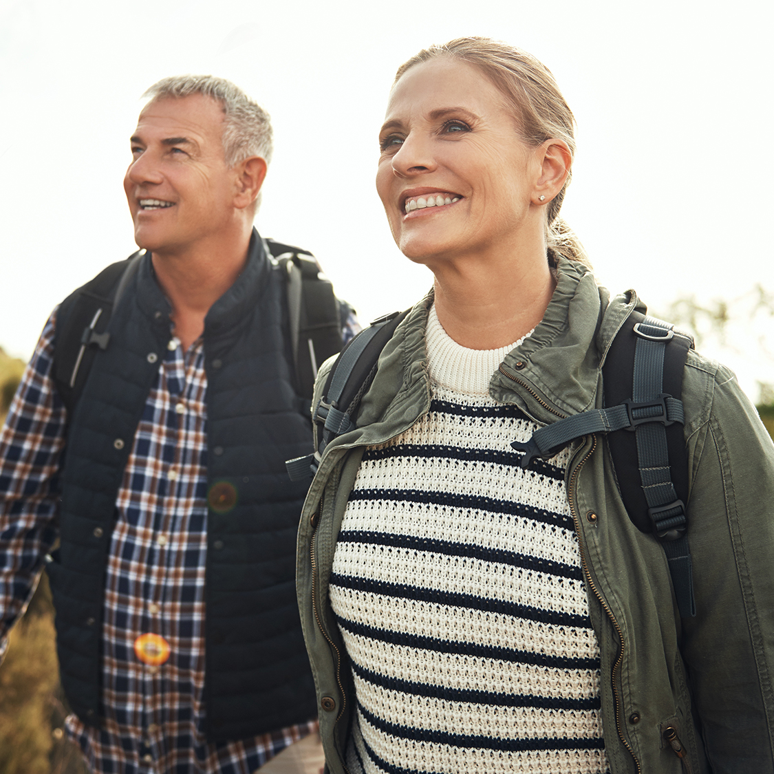 Middle aged husband and wife hiking, happy after receiving SLT laser treatments. 