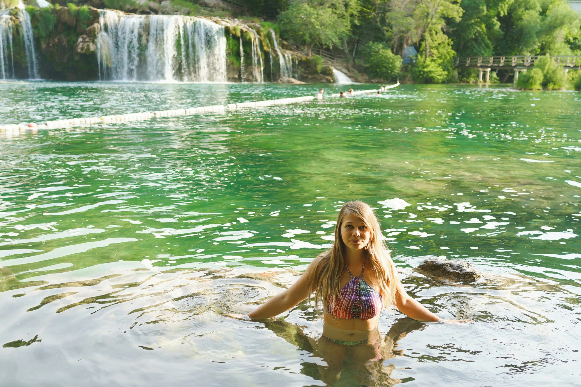 Ina swimming under the waterfall