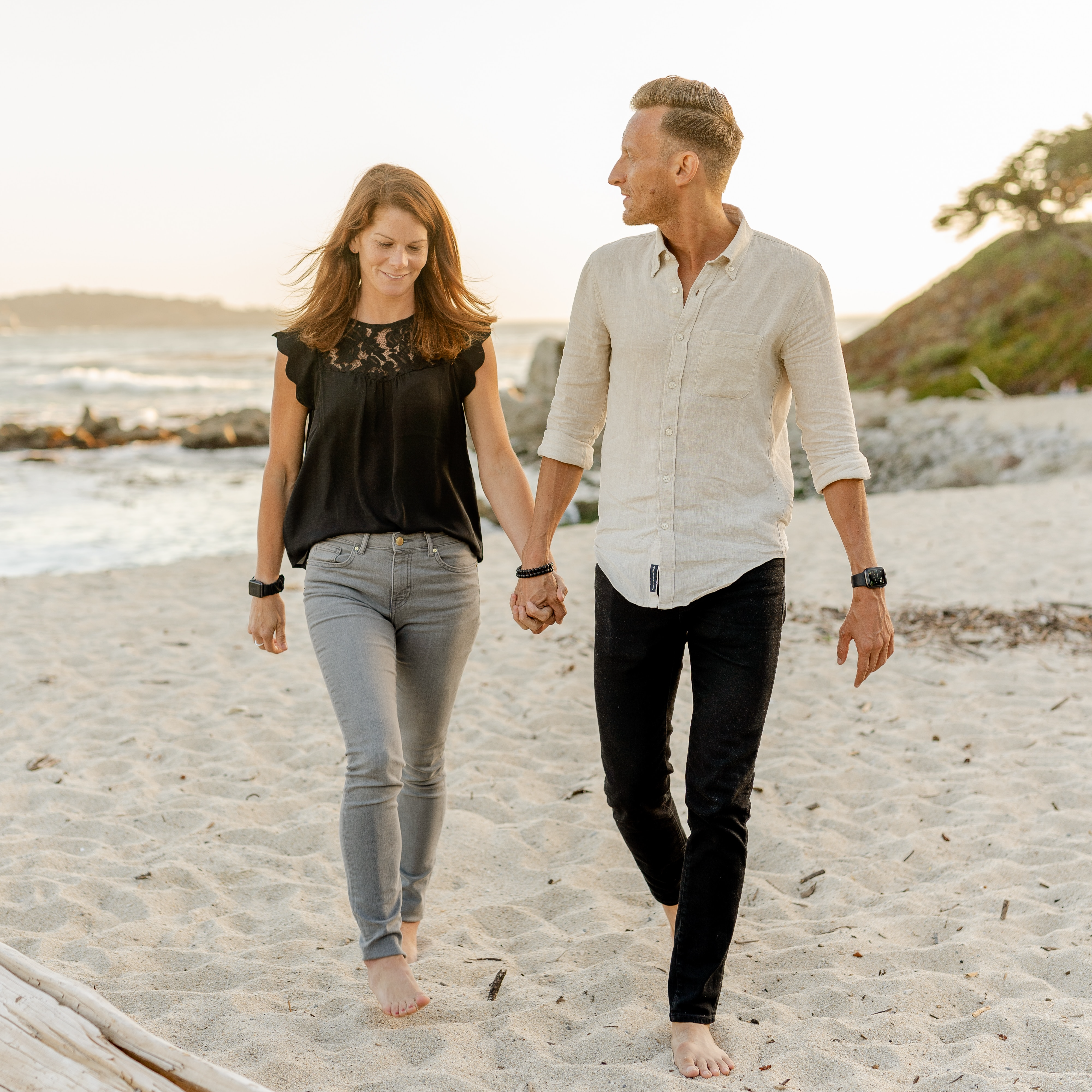 man and woman walking on the beach