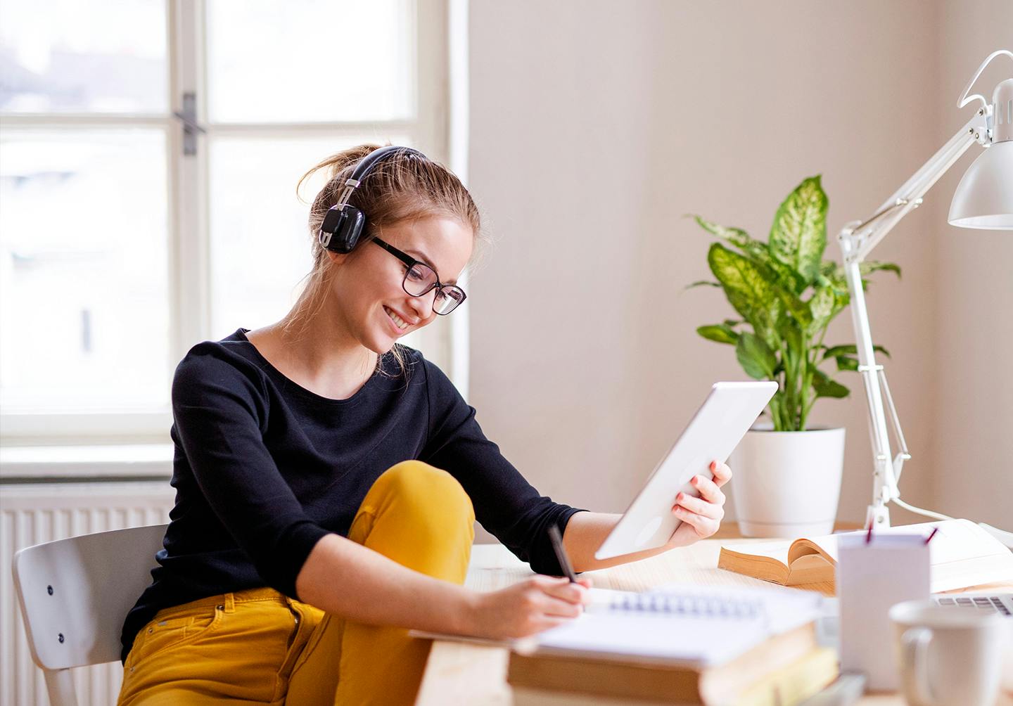 there is a woman sitting at a desk with a tablet computer