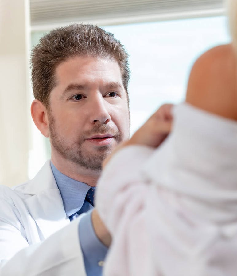 there is a male doctor looking at a woman's breast