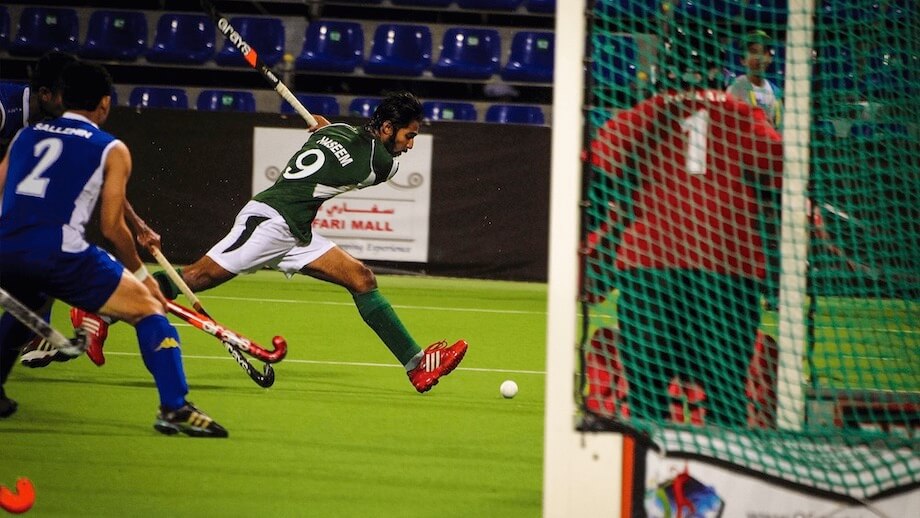 Indian player shooting in field hockey