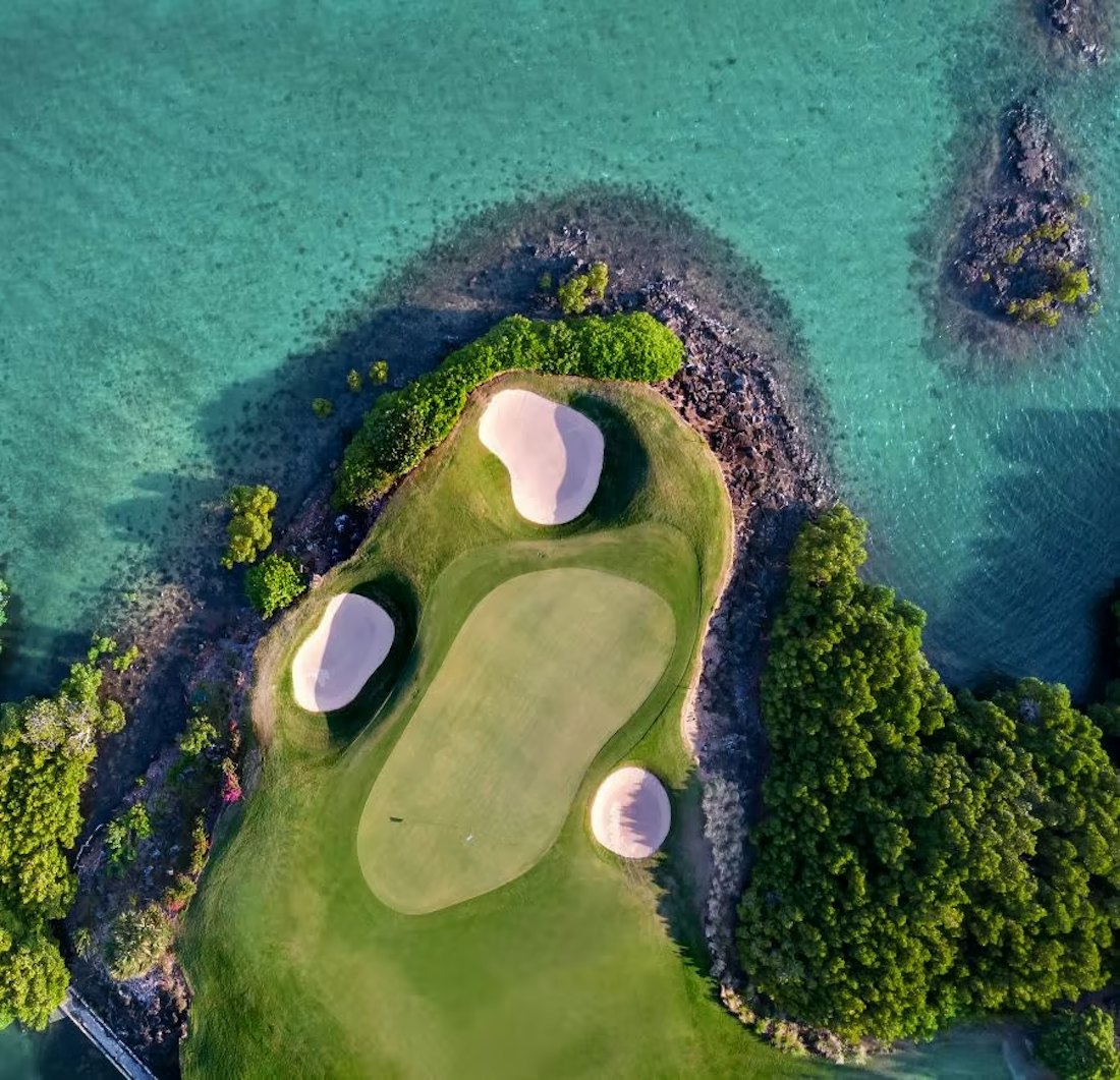 Aerial view of the Ernie Els golf course at Anahita, green ringed by lagoon