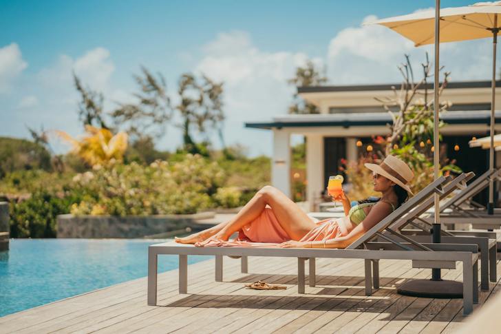 Infinity pool at the Saint Antoine estate, sun loungers facing the lagoon (developer photo)