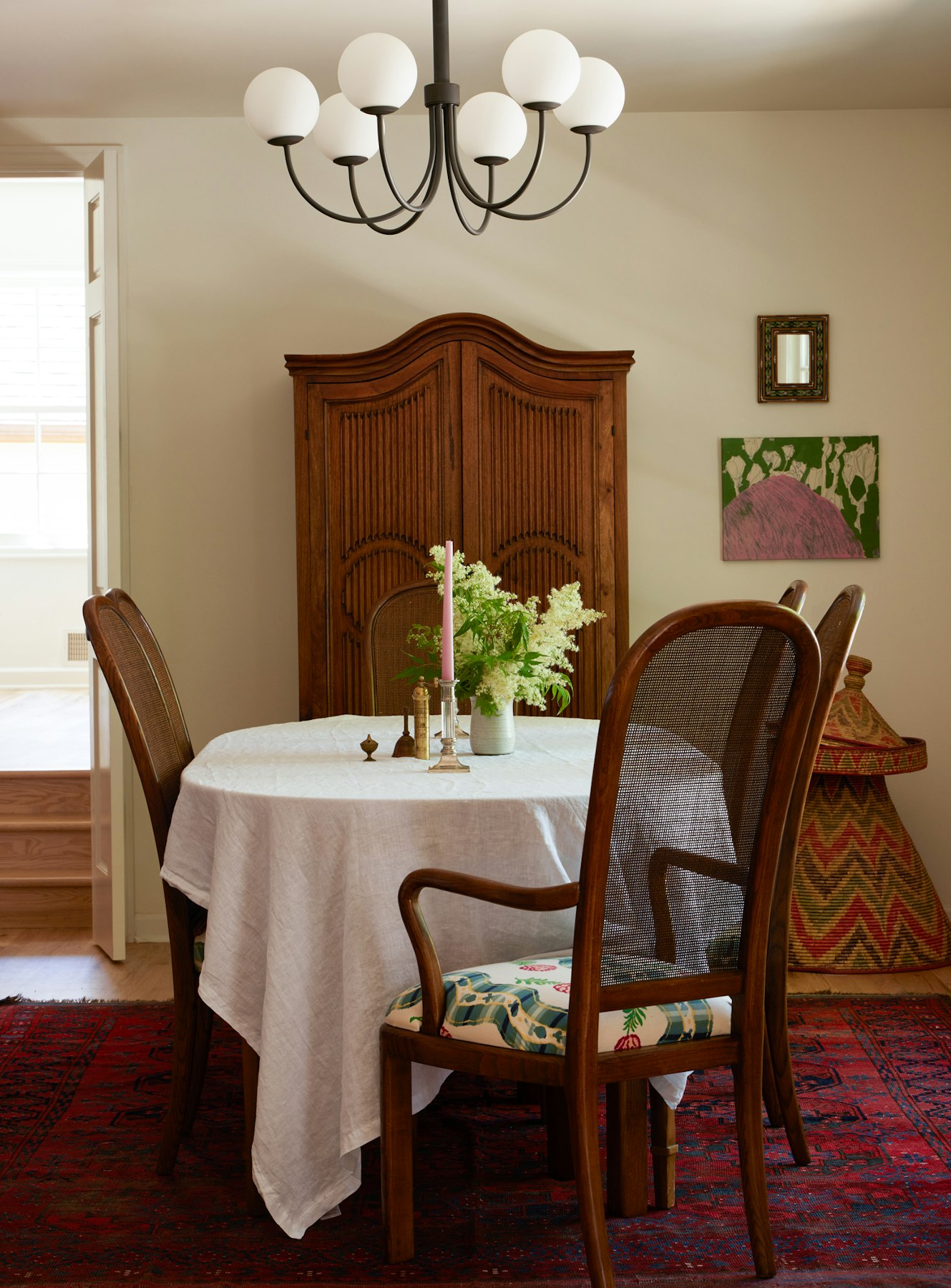 oval table with cane back chairs and chandelier overhead