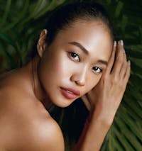 Closeup of a woman's face with foliage in the background