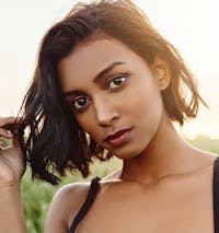 Closeup of a model's face with the sun in the background