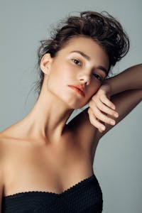 Brunette woman posing in a black top.